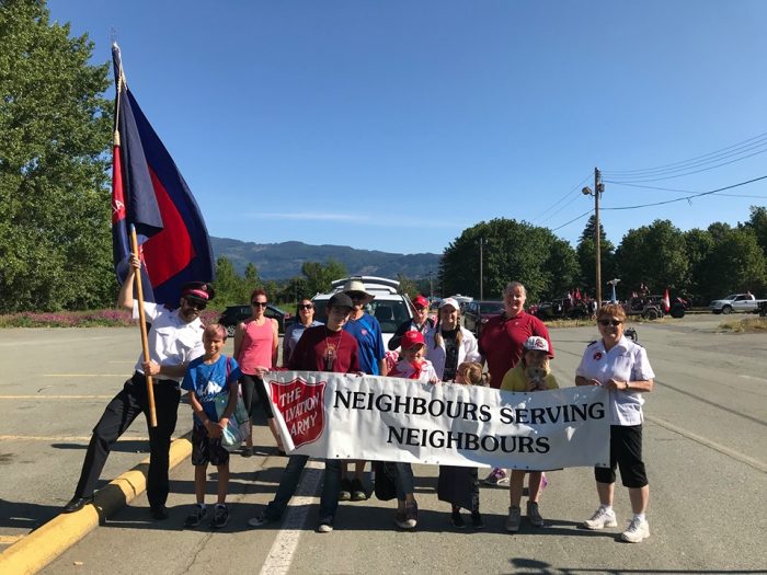 Group of Alberni Valley Ministries participants holding a “Neighbours Serving Neighbours” banner.